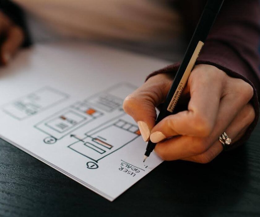 Person writing down the website plan